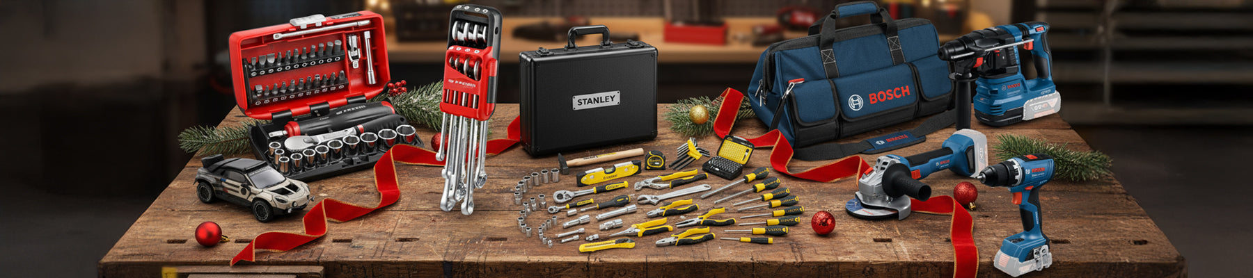 Le Pack Facom OGV® Grip NANO, le Stanley 119 pcs, et le KIT 3 OUTILS Bosch, sur un fond d'atelier avec un rappel de Noël.
